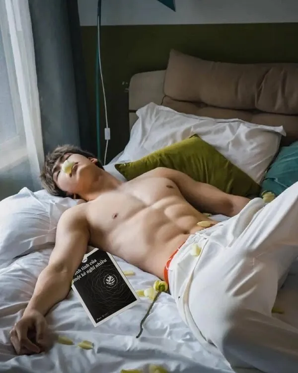 Hình ảnh hot boy đẹp trai có một người đàn ông không mặc áo nằm trên giường với cuốn sách