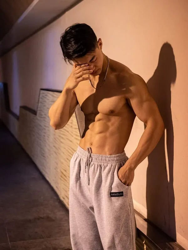 Hình hot boy đẹp trai có một người đàn ông không mặc áo dựa vào tường bằng tay