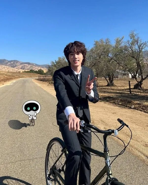 Hình ảnh jin bts có một người đàn ông trong bộ đồ đi xe đạp trên đường
