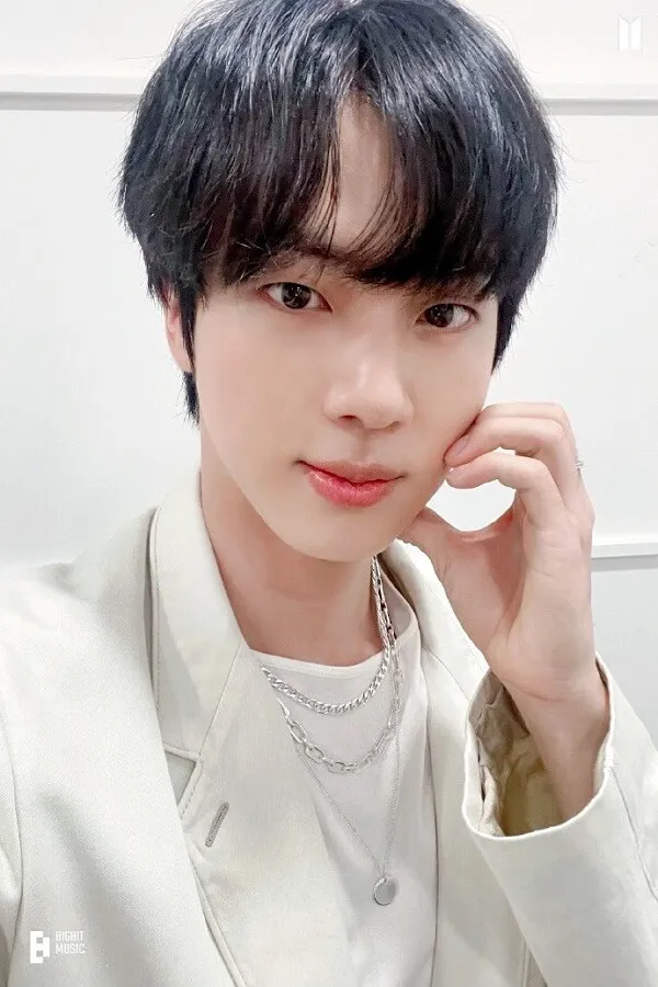 Hình ảnh jin bts đây là cận cảnh của một người mặc áo sơ mi trắng và khoác
