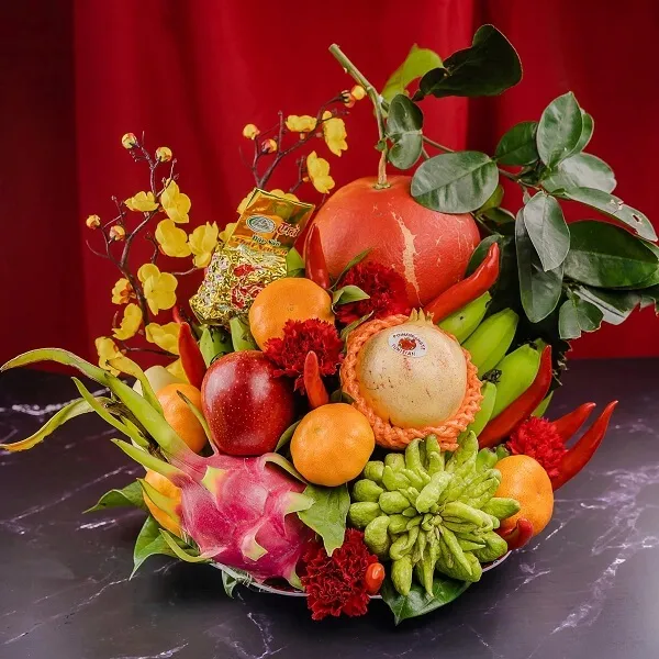 Mâm ngũ quả trung thu một số trái cây và rau được sắp xếp trong cái bát trên bàn