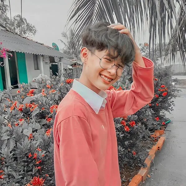 Hình ảnh trai đẹp 12 tuổi có một cậu bé kính đứng trước vườn hoa