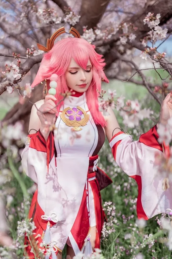 Ảnh yae miko cosplay có một người phụ nữ mái tóc màu hồng trên cánh đồng hoa