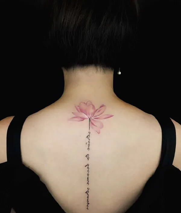 Lưng của một người phụ nữ có hình xăm hoa màu hồng trên