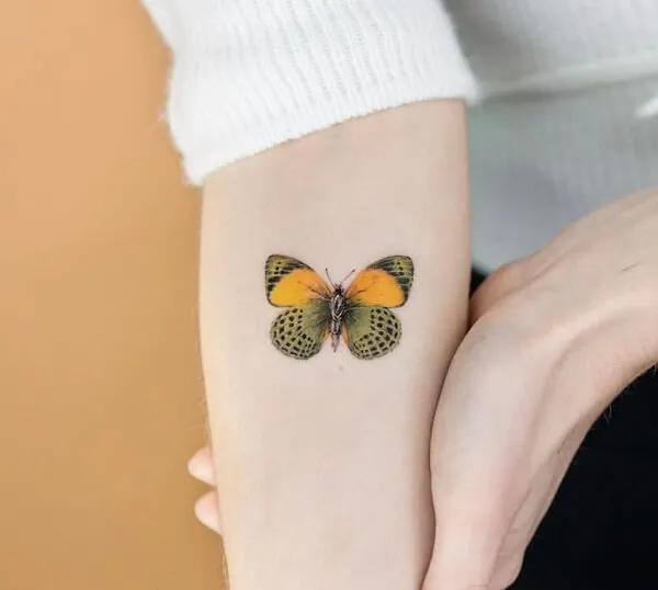 Có một hình xăm con bướm nhỏ trên cánh tay của người phụ nữ