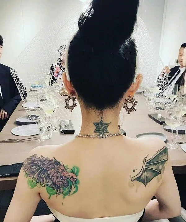 Có một người phụ nữ hình xăm trên lưng ngồi bàn