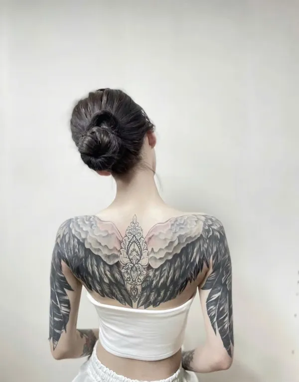 Có một người phụ nữ mặc chiếc váy trắng với hình xăm trên lưng