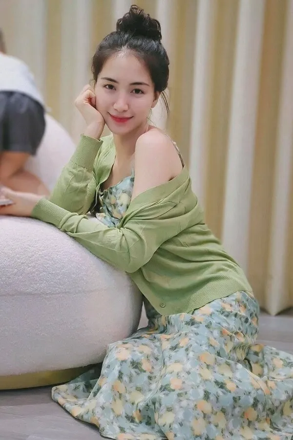 Hòa minzy sexy có một người phụ nữ đang ngồi trên sàn với hai chân của cô ấy vượt qua