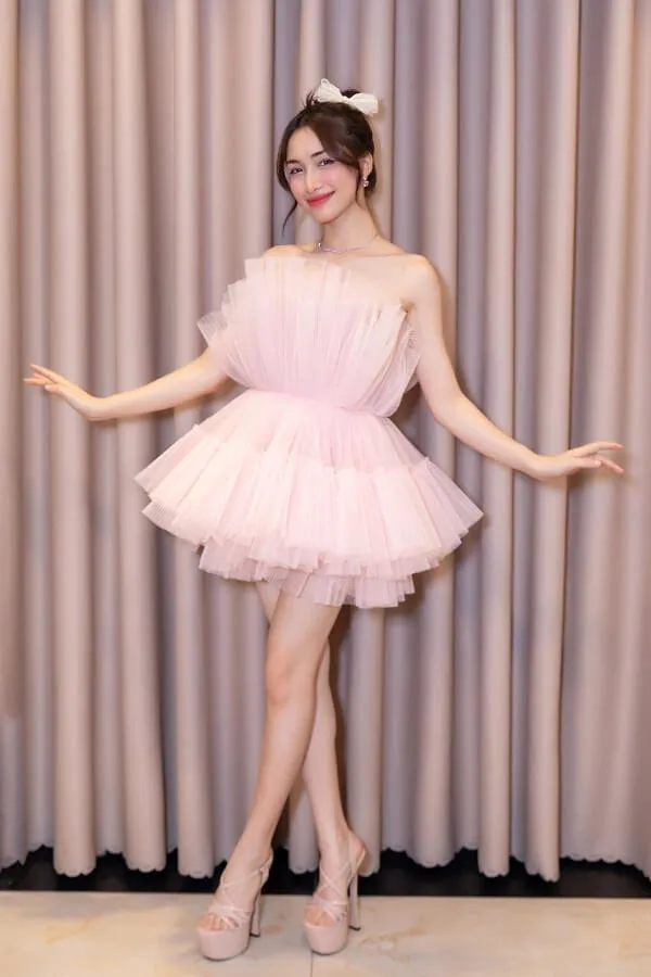 Hòa minzy sexy có một người phụ nữ mặc chiếc váy màu hồng tạo dáng cho bức tranh