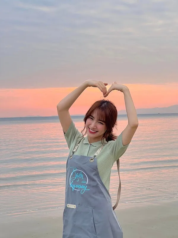 Hòa minzy sexy có một người phụ nữ đang đứng trên bãi biển với đôi tay trong không khí