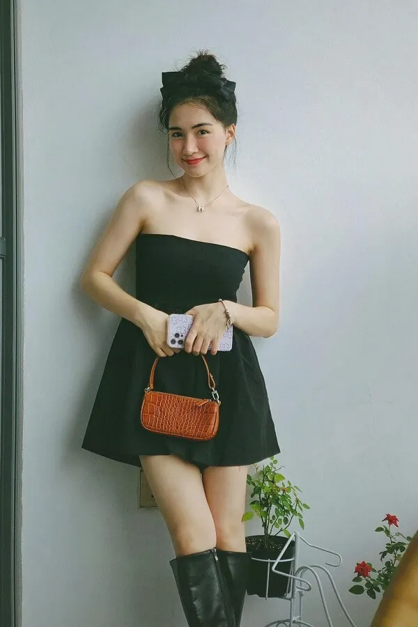 Hòa minzy sexy có một người phụ nữ đứng cạnh bức tường cầm ví