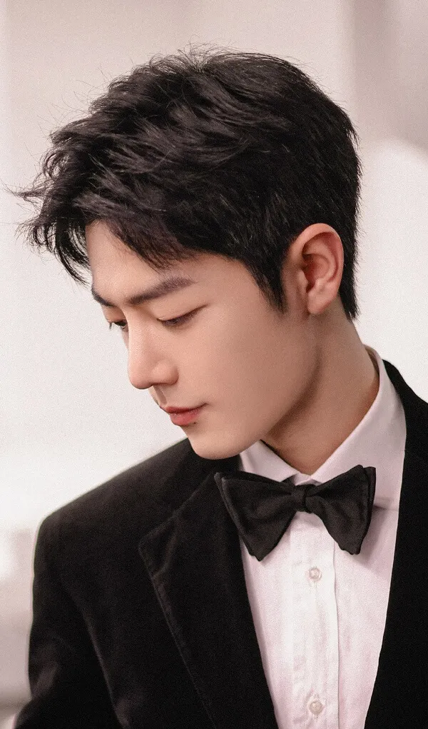 Hot boy ảnh trai đẹp trung quốc tik tok có một người đàn ông trong bộ tuxedo nhìn xuống điện thoại di động của anh ta