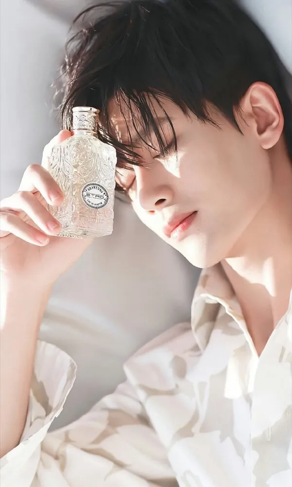 Hot boy ảnh trai đẹp trung quốc tik tok người đàn ông châu nằm trên giường với một chai nước hoa trong tay