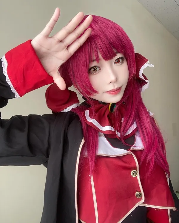 Houshou marine cosplay có một người phụ nữ mái tóc màu hồng mặc trang phục đỏ và đen