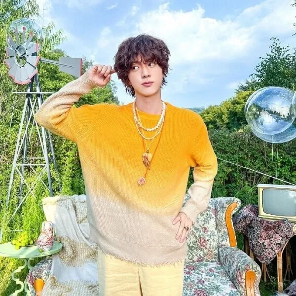 Ảnh jin bts có một người đàn ông đang đứng trước chiếc ghế dài