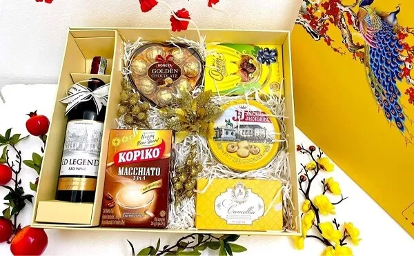 Khay gỗ đựng quà tết có một hộp thức ăn và chai rượu vang trên bàn