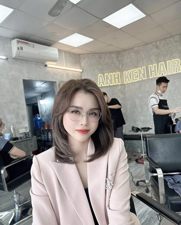 Tóc layer nữ người phụ trẻ với kính ngồi trong tiệm đang chờ