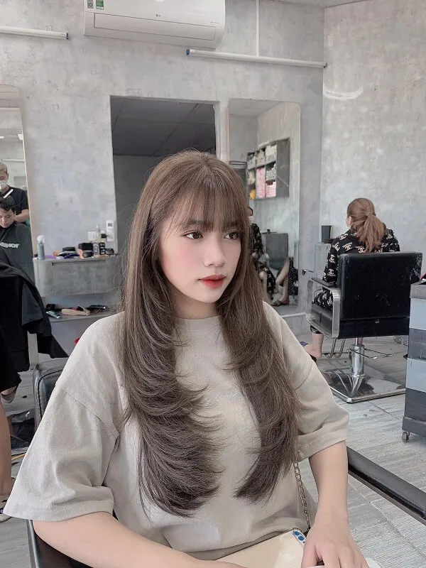 Tóc mullet layer nữ có một người phụ ngồi bàn trong tiệm làm