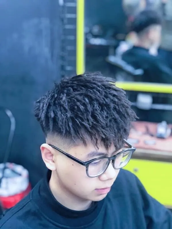 Tóc mohican có một chàng trai trẻ ngồi trong cửa hàng cắt