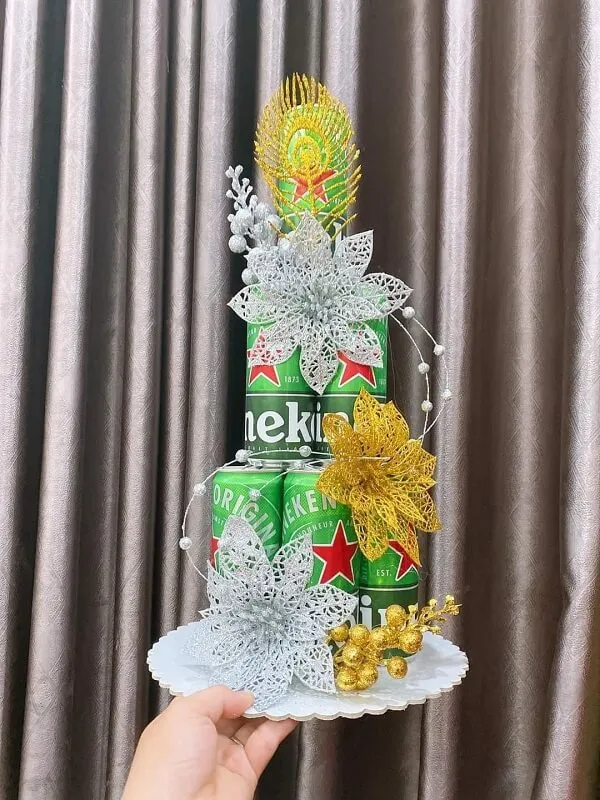 Có một người cầm bánh được làm giống như lon bia