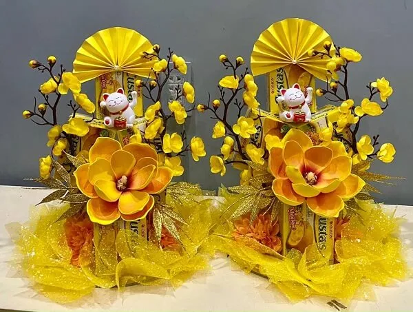 Hoa vàng và cam nằm trong một cái giỏ trên bàn