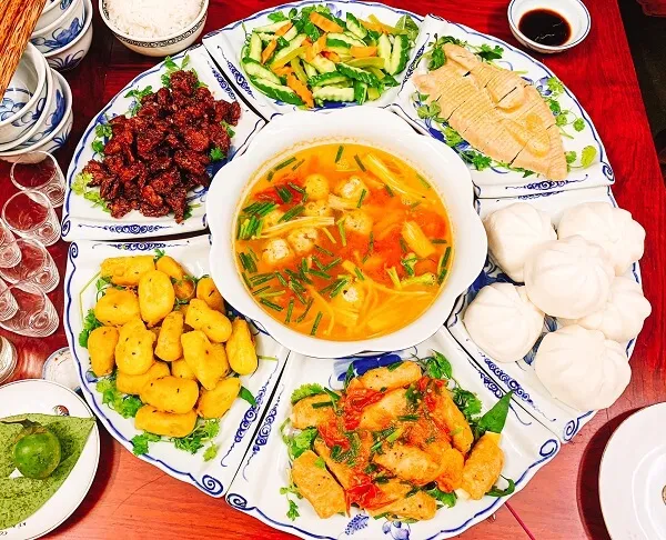 Một số đĩa thức ăn được sắp xếp trên bàn với ly rượu