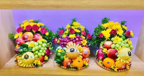 Mâm ngũ quả ngày tết có một loạt các loại trái cây và hoa được trưng bày trên kệ