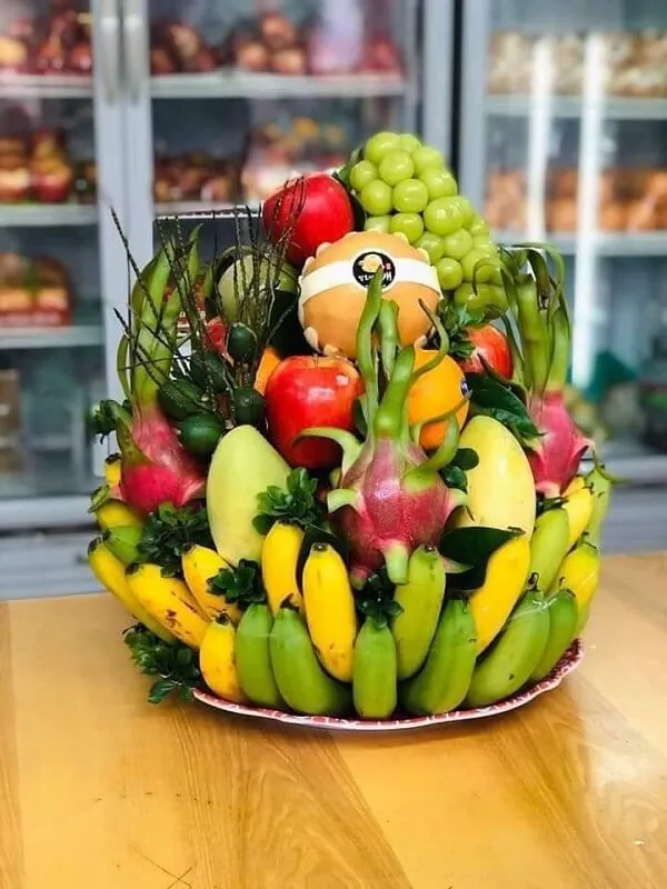 Mâm ngũ quả ngày tết trái cây và rau được sắp xếp trong một cái giỏ trên bàn gỗ