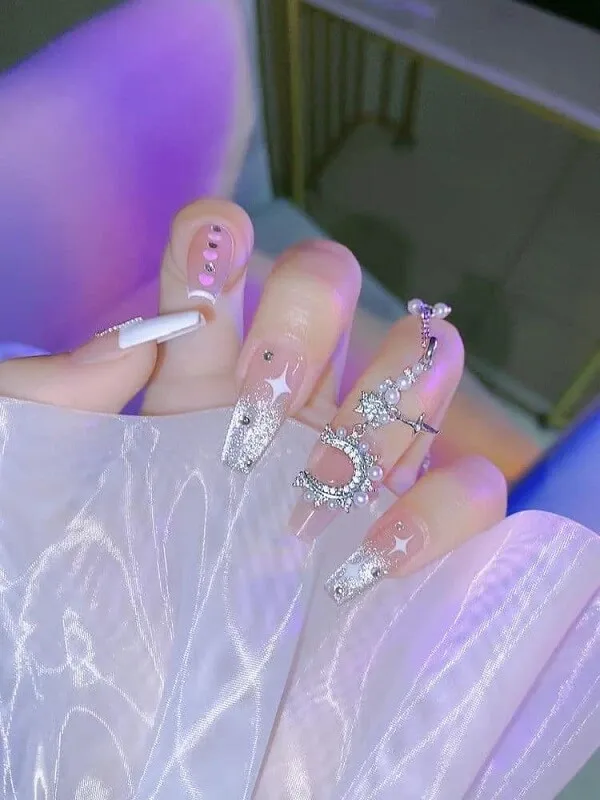 Mẫu nail cô dâu có một bàn tay của người với móng trắng và bạc