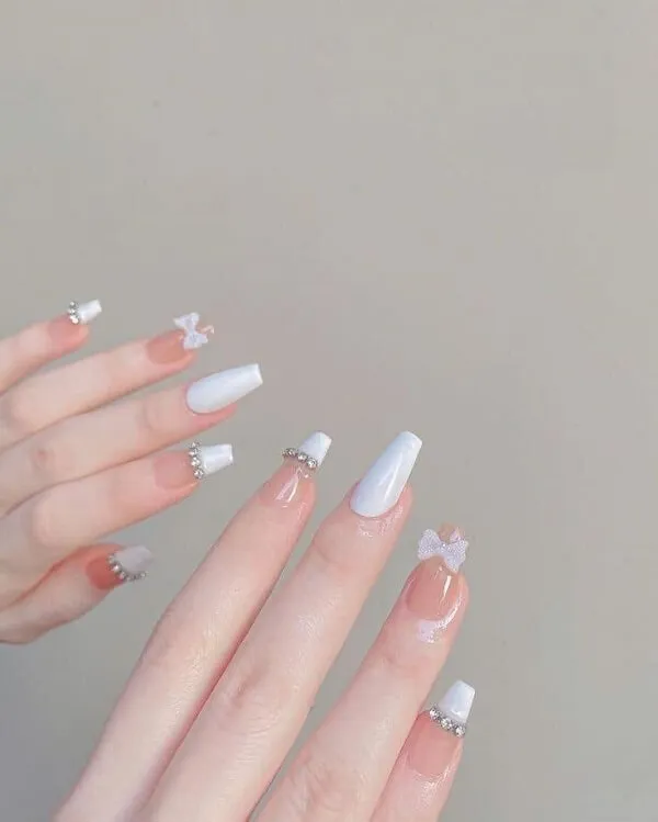 Mẫu nail cô dâu đây là cận cảnh tay của một người với sơn móng trắng