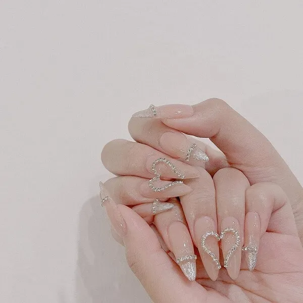 Mẫu nail cô dâu người phụ nữ đang cầm móng tay trong khi đeo nhẫn kim cương