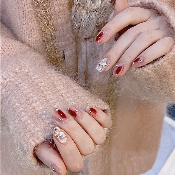 Mẫu nail đẹp đây là một bàn tay của người phụ nữ với móng màu đỏ và trắng