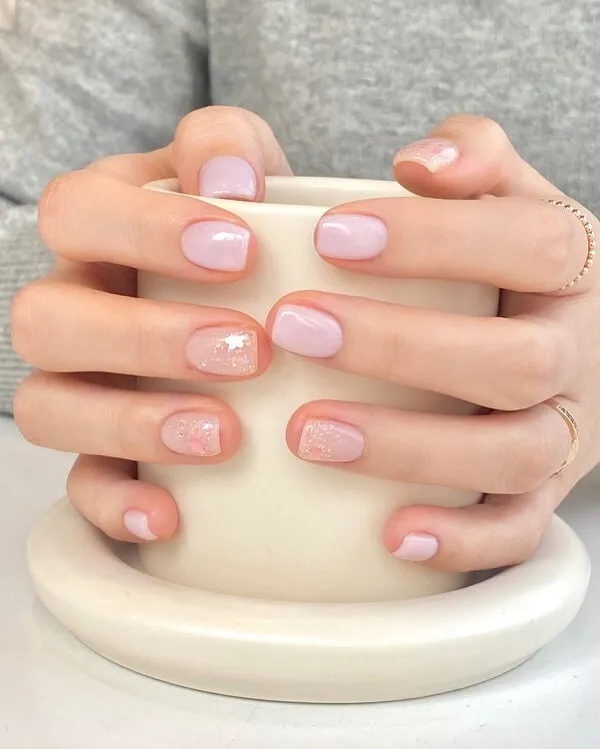 Mẫu nail đơn giản có một người phụ nữ cầm tách cà phê và mặc sơn móng tay màu hồng