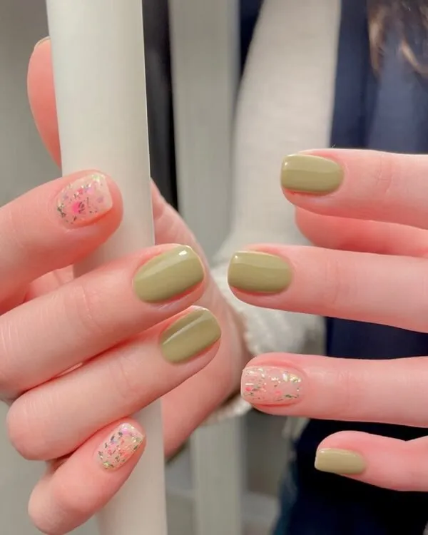 Mẫu nail đơn giản nhẹ nhàng đây là một cận của bàn tay người với móng màu xanh lá cây