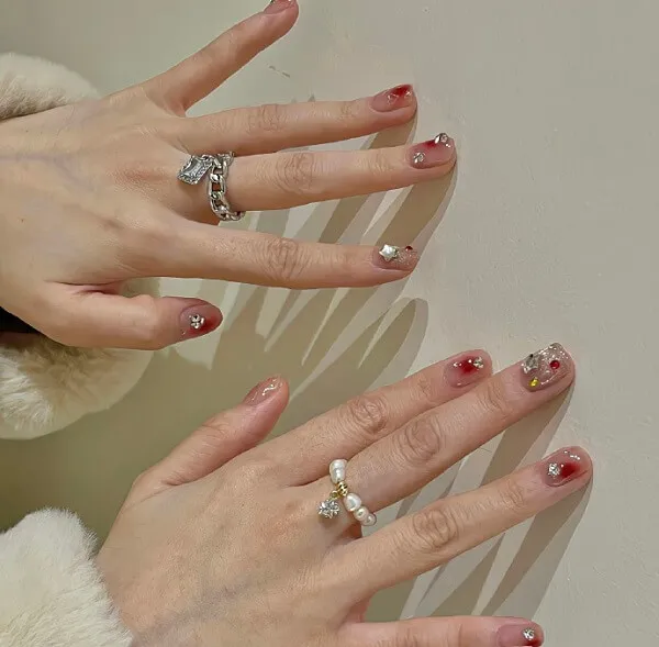 Mẫu nail đẹp đây là hình ảnh bàn tay của một người phụ nữ với sơn móng màu đỏ và trắng