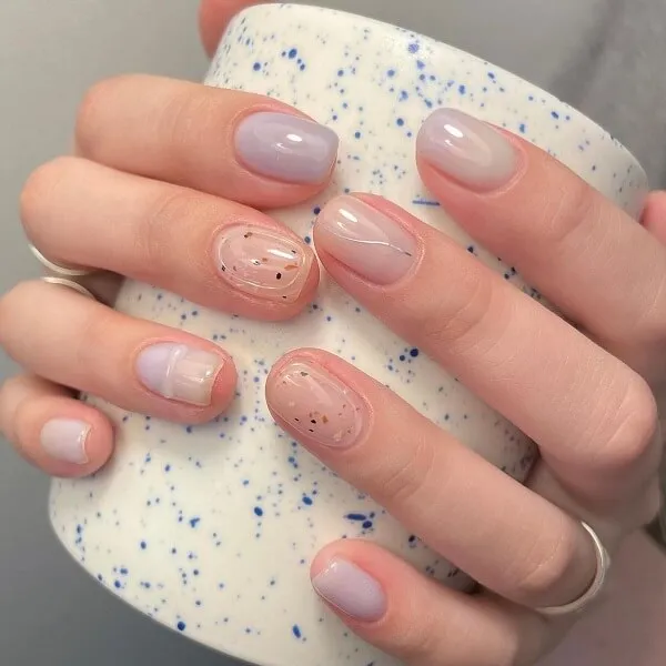 Mẫu nail đơn giản có một người phụ nữ cầm cốc cà phê với thiết kế màu hồng và xanh trên đó