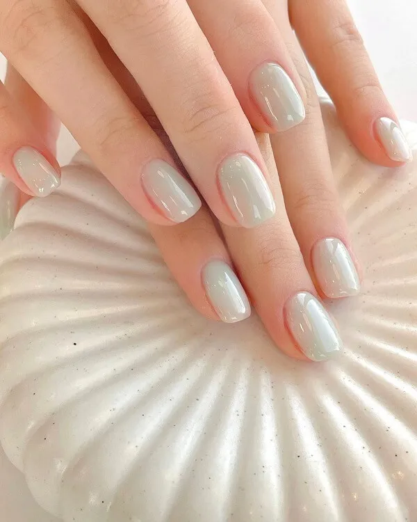 Mẫu nail đơn giản có một bàn tay của người với móng màu trắng