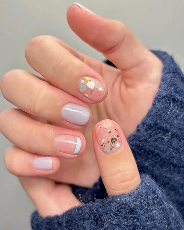 Mẫu nail đơn giản có một người cầm móng tay màu hồng và trắng với hoa trên đó
