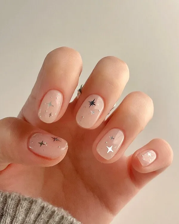 Mẫu nail đơn giản nhẹ nhàng đây là hình ảnh bàn tay của một người phụ nữ với móng màu hồng và bạc