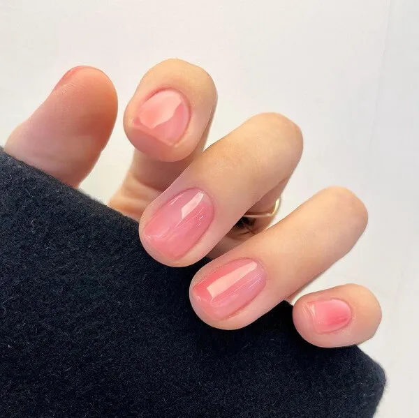Mẫu nail đơn giản nhẹ nhàng có một bàn tay của người với móng màu hồng