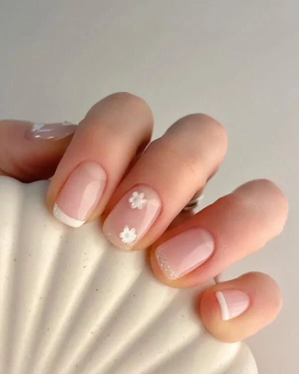 Mẫu nail đơn giản sang trọng ai đó đang cầm một cái vỏ với thiết kế hoa màu trắng trên
