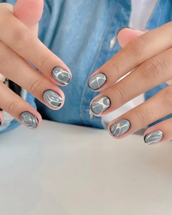 Mẫu nail đẹp đơn giản đây là một bàn tay của người với móng màu xám và trắng