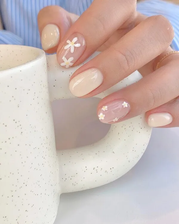 Mẫu nail đơn giản sang trọng có một người phụ nữ cầm tách cà phê với thiết kế hoa trên đó