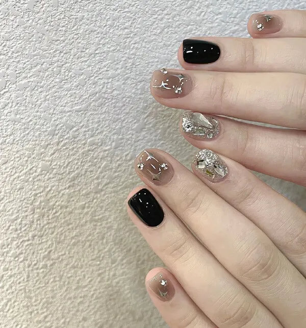 Mẫu nail mắt mèo đẹp đây là một cận của bàn tay người với móng màu đen và vàng
