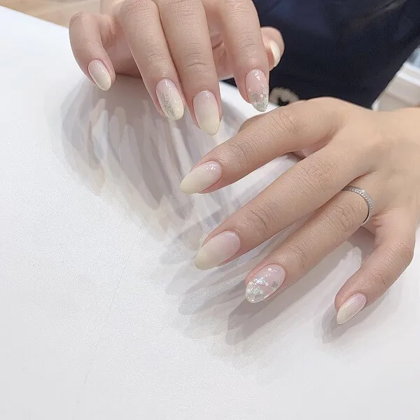 Mẫu nail trắng có một bàn tay của người với chiếc nhẫn trên đó