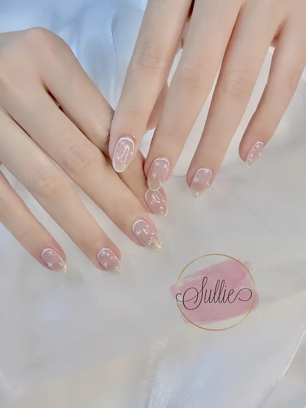 Mẫu nail trắng có một bàn tay của người với móng màu hồng và