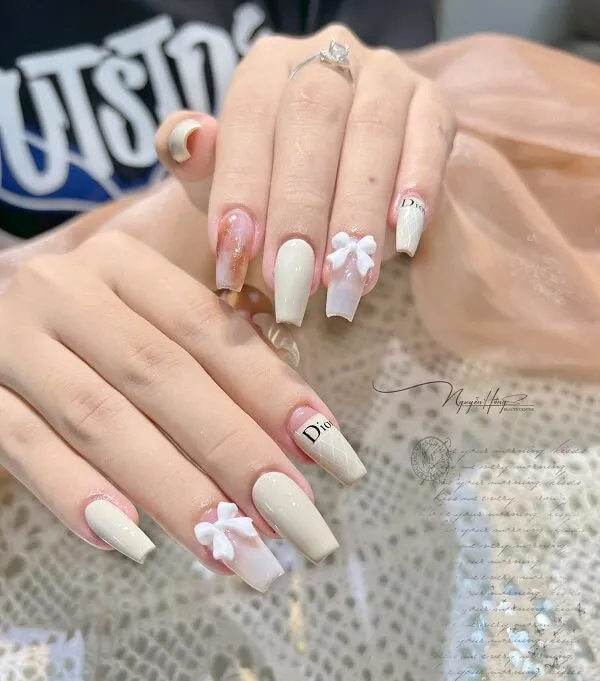 Mẫu nail trắng đây là cận cảnh của một người với thiết kế móng tay và hồng
