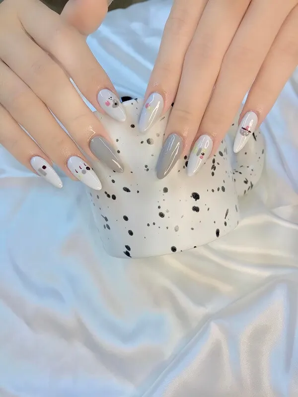 Mẫu nail trắng có một bàn tay của người với móng màu và đen