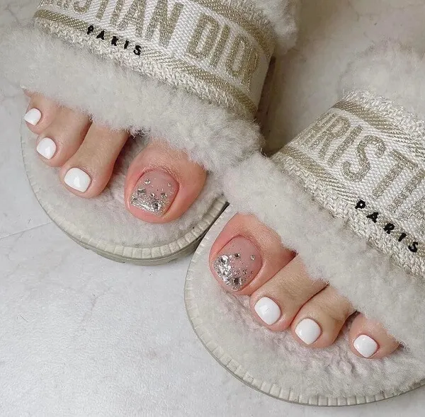 Nail chân màu trắng sữa cặp đôi dép với móng long lanh ngồi trên giường