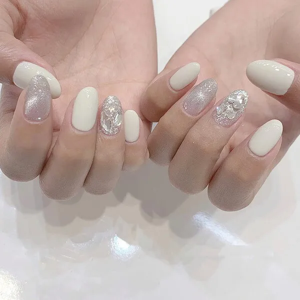 Mẫu nail trắng sang chảnh đây là cận cảnh của hai bàn tay với móng và bạc